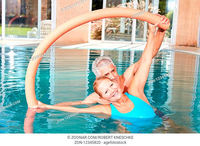 Senioren Paar macht mit der Schwimmnudel eine Wassergymnastik Übung
