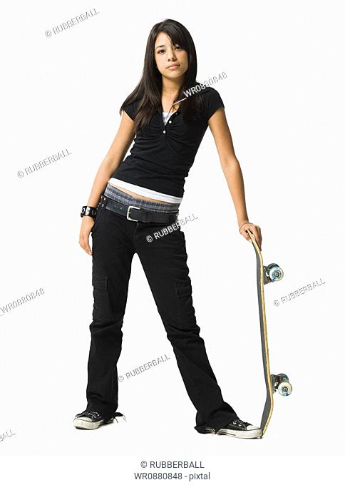 Teenage girl standing and holding a skateboard
