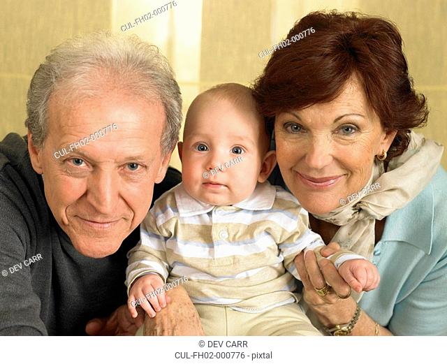 Senior grandparents with baby grandson 1-3 months smiling, portrait