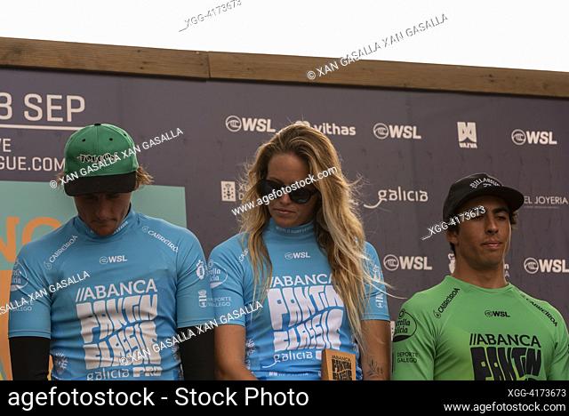 surfer Camilla Kemp receives the runner up trophy. on the left the finalist Charly Quivront and on the right of the image Joaquim Chaves