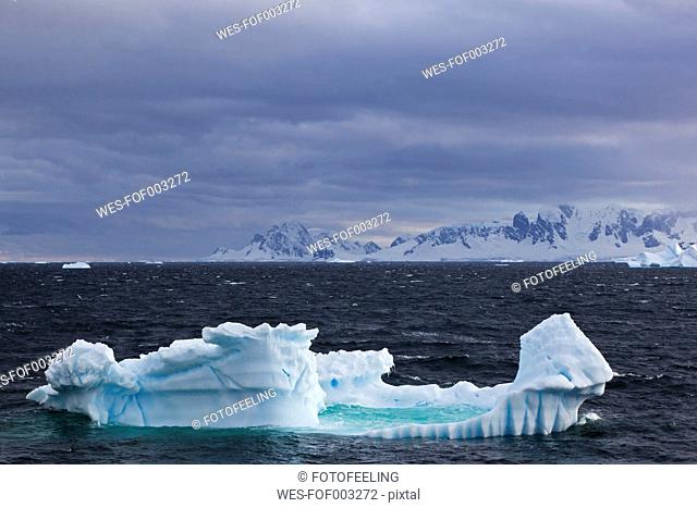 South Atlantic Ocean, Antarctica, Antarctic Peninsula, Gerlache Strait, View of iceberg with snow-covered mountain range