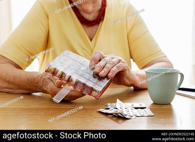 Woman's hands holding pill organizer