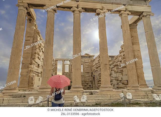 Tourist woman with umbrella at The Parthenon or Temple of Athena on Athenian Acropolis in Greece