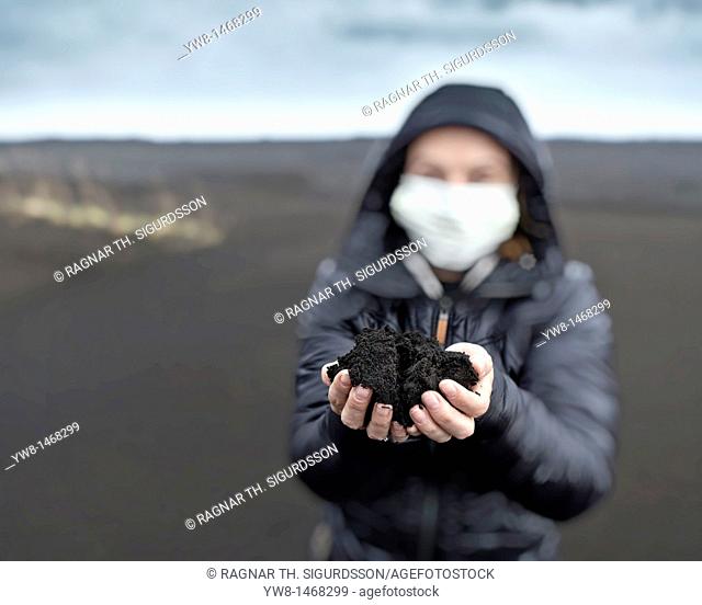 Woman holding new ash from recent Grimsvotn volcanic eruption, Iceland  Skeidararsandur outwash plains covered with ashfall  Eruption began on May 21, 2011