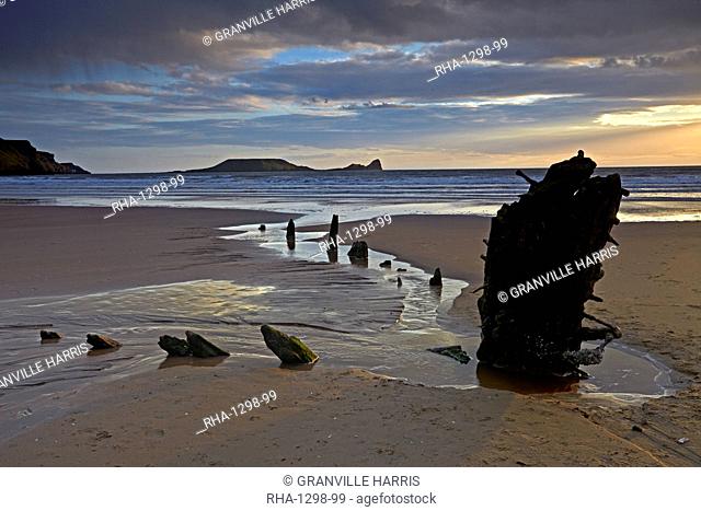 Sunset over the wreck of the Helvetia and Worms Head at Rhossili Bay, Gower, Wales, United Kingdom, Europe