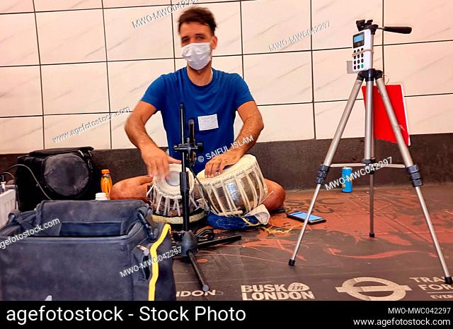 London. United Kingdom. 16th September 2021. A tabla player busking on the London Underground, at Moorgate station. His touch screen allows donations to be...