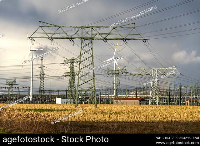 13 March 2021, Saxony-Anhalt, Wolmirstedt: Dark rain clouds have gathered behind the Wolmirstedt substation. From here, a 580-kilometre-long power line is to be...