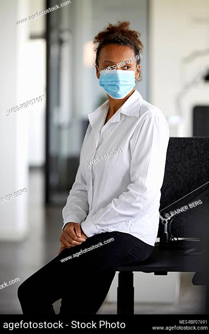 Portrait of businesswoman wearing light blue protective mask