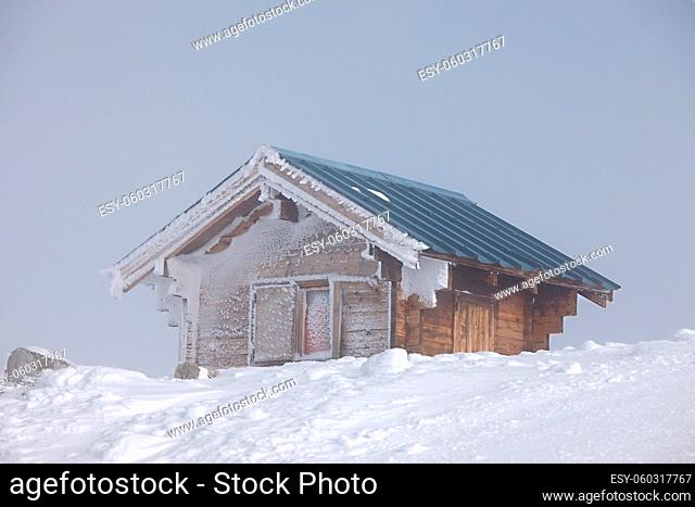 Wooden fut on a frozen frosty mountain top in winter