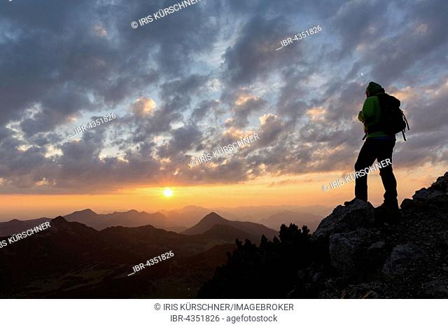 Hikers looking in the distance, sunrise at Krottenkopf, Ester Mountains, Garmisch-Partenkirchen District, Bavaria, Germany