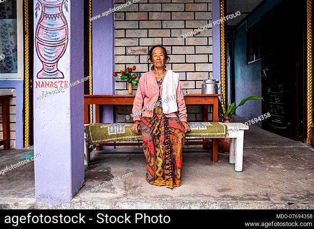 Portrait of a woman sitting outside her guest house. Annapurna Conservation Area (Nepal), August 21st 2019