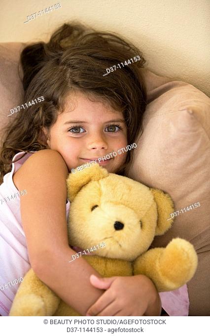 Caucasian girl hugging her teddy bear
