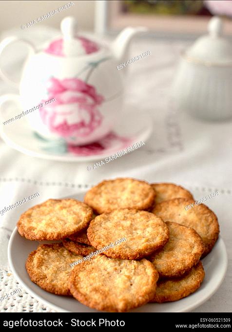Biscuits on table, ready to be taken with tea. Teapot with floral motifs and various complementary elements