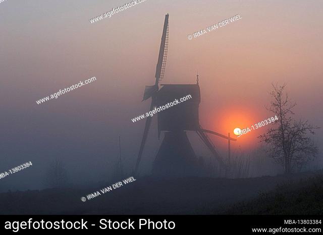 Impressions of a spring hike at sunrise and fog in South Holland in the Alblasserwaard Vijfheerenlanden region near Kinderdijk: windmill at sunrise and fog