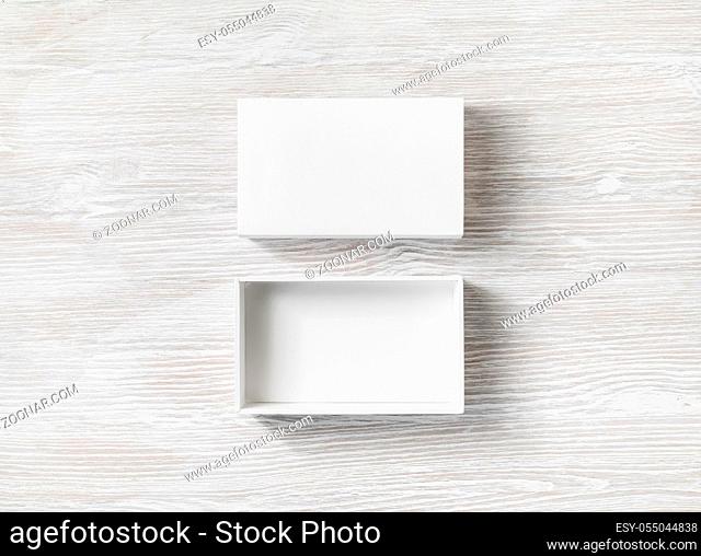 White cardboard box with cover on light wooden background. Flat lay