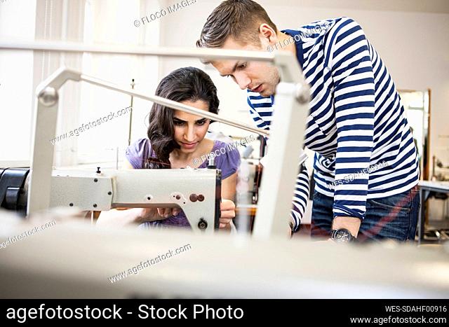 Young man and seamstress at work in a tailor shop