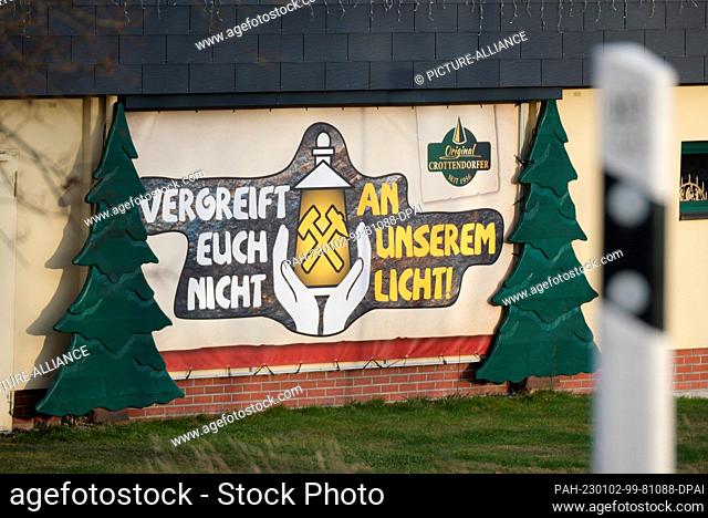 02 January 2023, Saxony, Crottendorf: ""Don't mess with our light"" is written on a banner on the facade of a building. The slogan is often seen in the Ore...