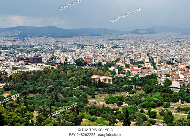 ATHENS, GREECE - MAY 6, 2014: View of the ancient agora with the temple of Hephaestus standing in contrast to the modern buildings of the city of Athens, Greece