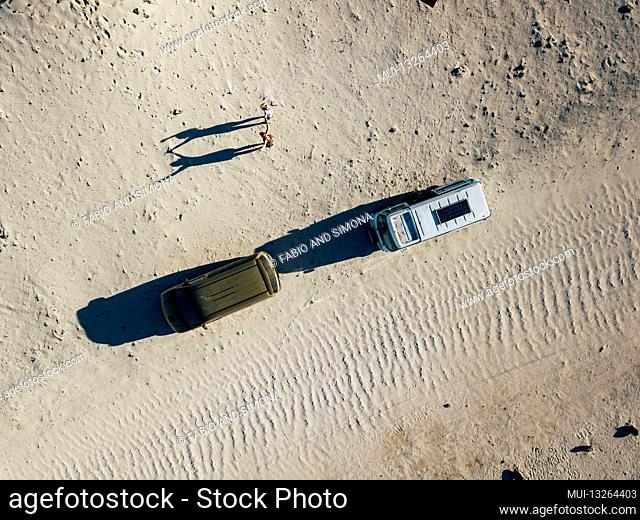 People enjoy travel with couple of women enjoying happy the trip with two vans vehicles parked on the sand - summer holiday alternative free vacation lifestyle...