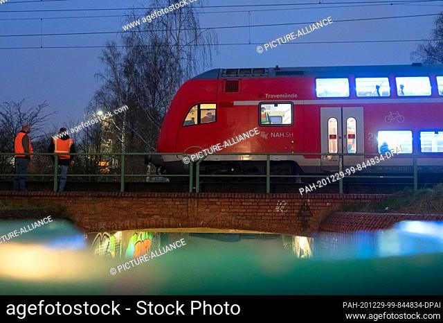 29 December 2020, Hamburg: Employees of Deutsche Bahn and the Federal Police are standing in front of and inside the regional express train