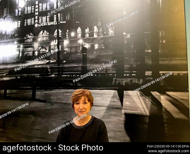 PRODUCTION - 29 March 2023, North Rhine-Westphalia, Bonn: Curator Agnieszka Lulinska stands in front of a large photograph of a Berlin street scene at night in...