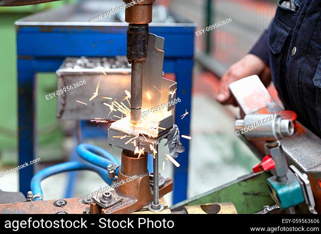 Close up of a metal element being spot-welded by a factory worker. Industry concept. High quality photo