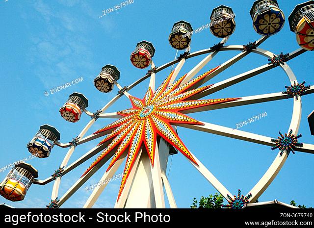 Bottom up view of Ferris wheel against blue sky in a park
