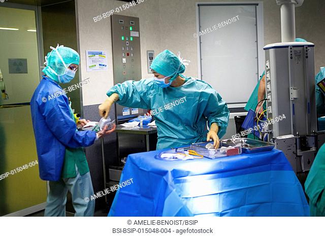 Reportage in an operating theatre during a hysterectomy using the da Vinci robot®. Two nurses prepare the material needed for the operation