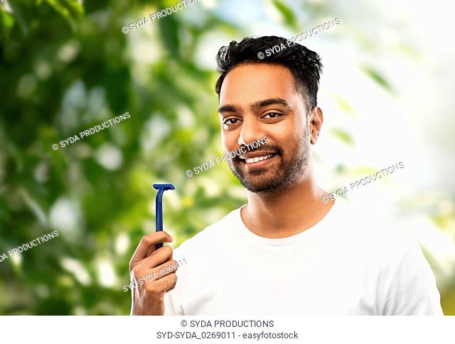 indian man with razor over natural background