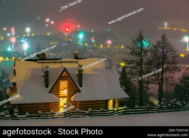 Cozy house in the mountains on the background of bright-scale New Year's fireworks. Tatra Mountains, Poland, Zakopane