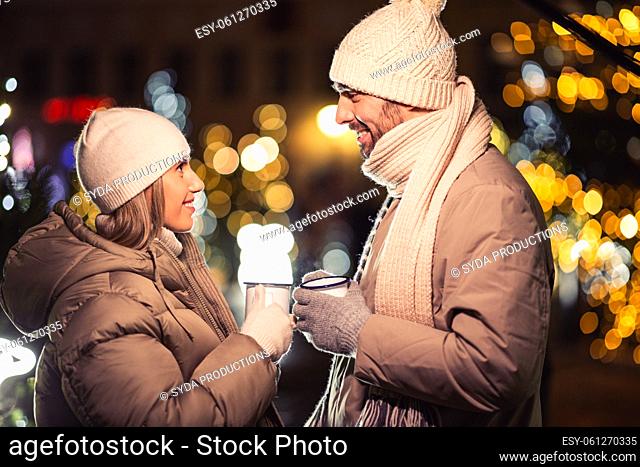 happy couple with tea cups over christmas lights