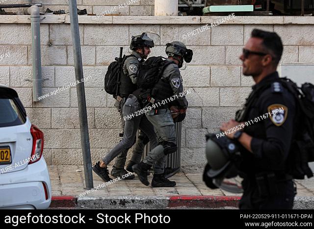 29 May 2022, Israel, Jerusalem: Israeli policemen arrest a Palestinian during clashes on Salah ad Din street after the Flag March