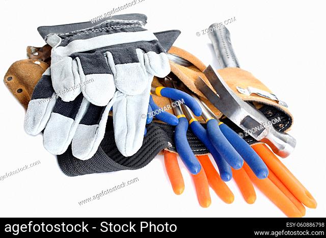 close up shot of a tool belt with wrench hammer and hand gloves