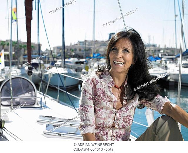 Mature woman relaxing on yacht, smiling, portrait