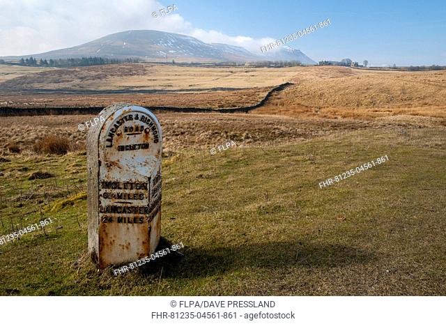 Mile marker showing six and quarter miles to Ingleton and 24 miles to Lancaster, on roadside near Ingleborough, Yorkshire Dales N.P