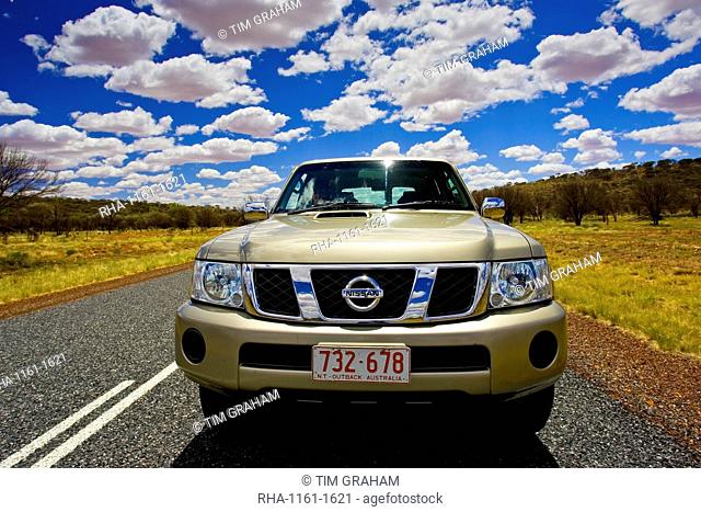 Four-wheel-drive Nissan Patrol vehicle on road in the Red Centre, Australia