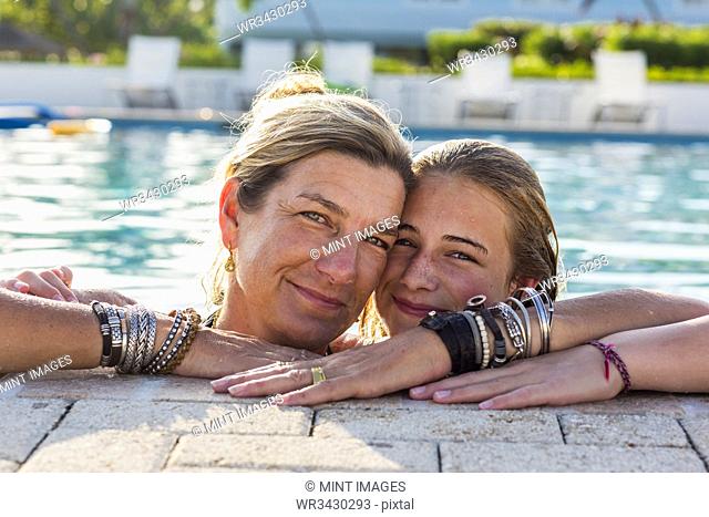 mother and her 13 year old daughter in pool smiling