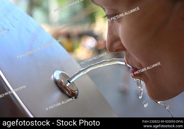 PRODUCTION - 22 August 2023, Rhineland-Palatinate, Mainz: Maren Brenning drinks from a drinking fountain on Rebstockplatz in downtown Mainz