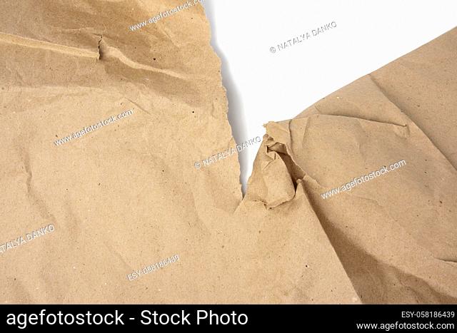 large piece of crumpled brown paper with torn edge isolated on white background, close up