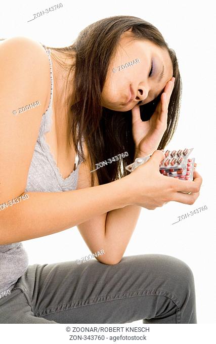 Junge depressive Frau hält einen Haufen Tabletten