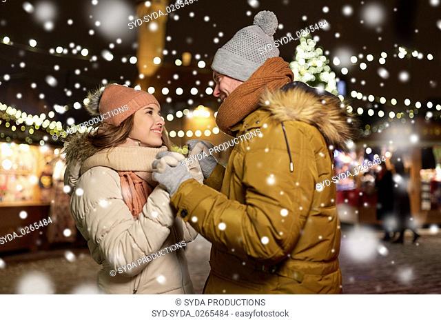 happy couple holding hands at christmas market