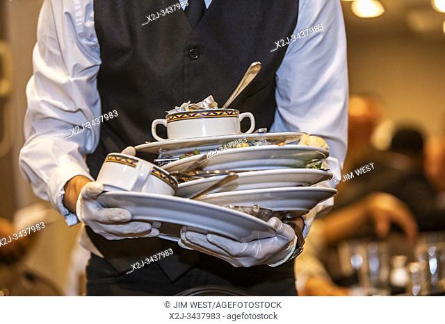 Chicago, Illinois - A waiter clears dishes away after a banquet at the Holiday Inn O'Hare