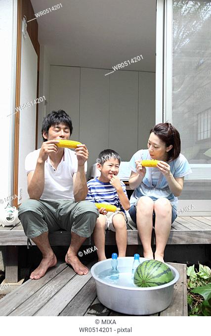 Family eating corn at verandah