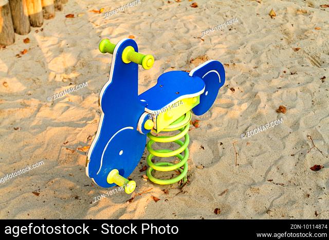 Photo of a blue rocking horse in the playground