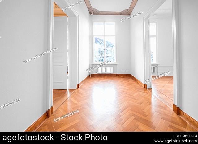 renovated old building room, flat with stucco ceiling and parquet floor -