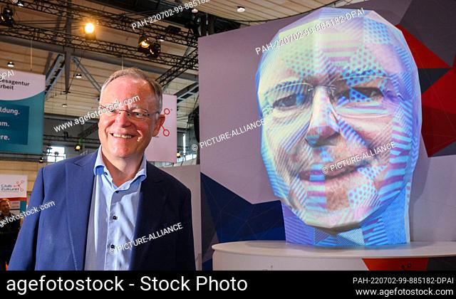 02 July 2022, Lower Saxony, Hanover: Stephan Weil (SPD), Minister President of Lower Saxony, stands in front of the projection of his face onto a...