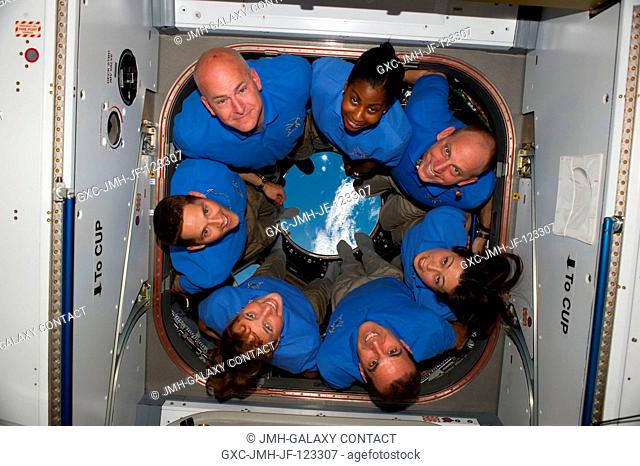 The STS-131 crew members pose for a portrait in the Cupola of the International Space Station while space shuttle Discovery remains docked with the station