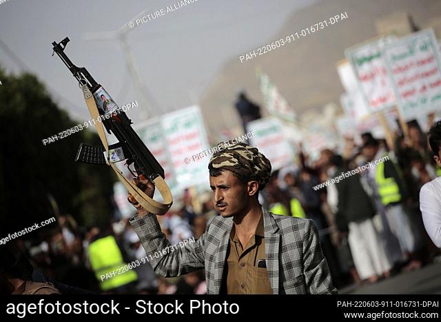 03 June 2022, Yemen, Sanaa: A houthi supporter carries a weapon during a protest against USA and Saudi Arabia calling on the end of war in Yemen