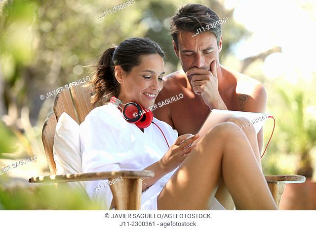Couple, digital tablet and headphones