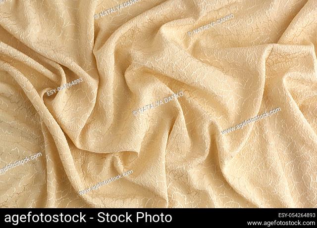 beige satin textile fabric with embroidery elements, piece of canvas for sewing curtains and things, full frame. Crumpled textile satin